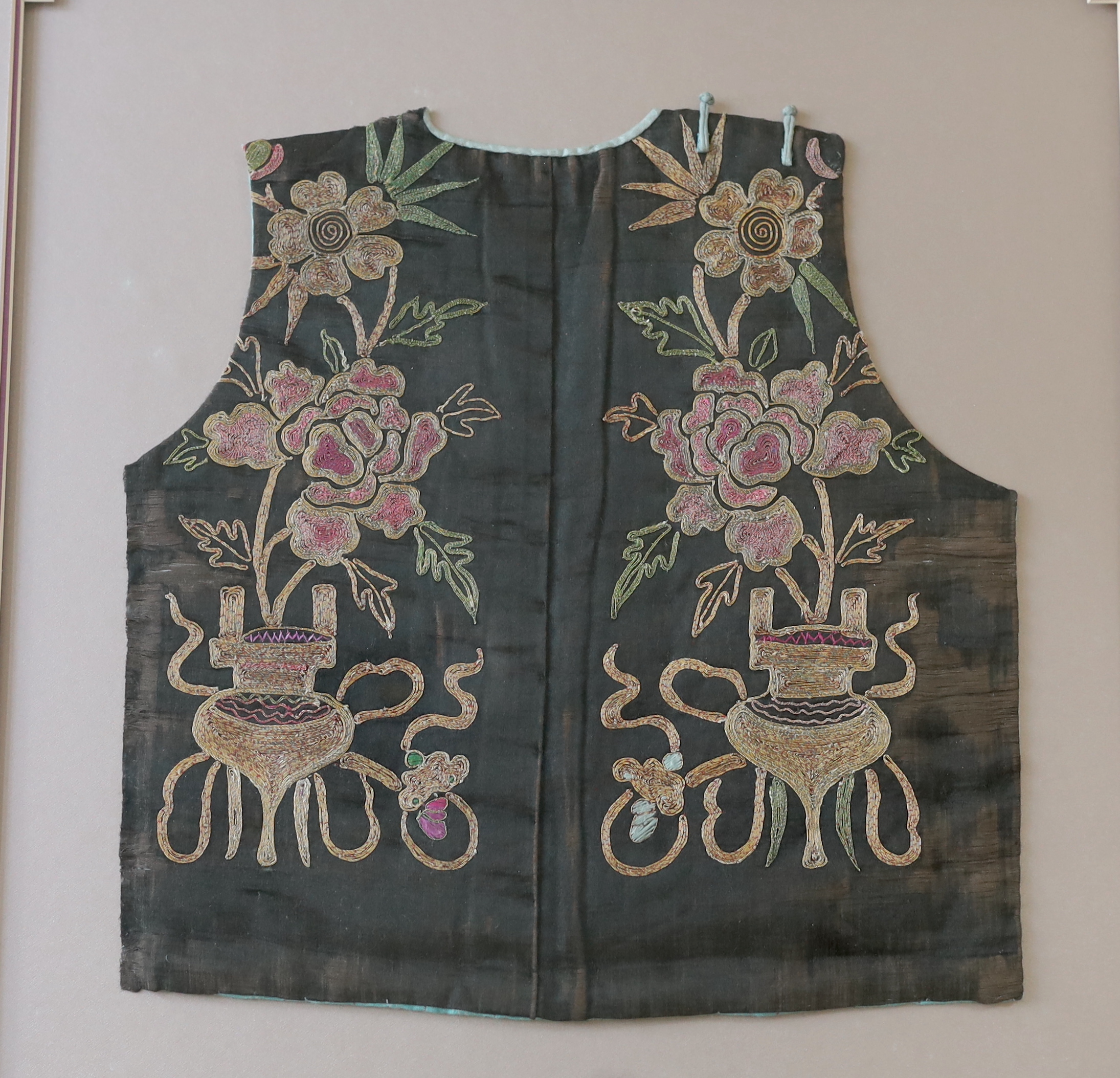 A late 19th century Chinese silk, multi-coloured metallic embroidered child's tabard front, together with a smaller, later silk and damask embroidered child’s waistcoat, larger panel: 34cm wide, 36cm high